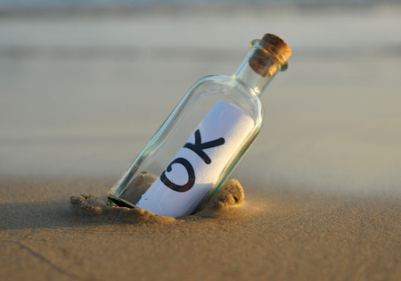 Bottle on the beach with ok insideの写真素材