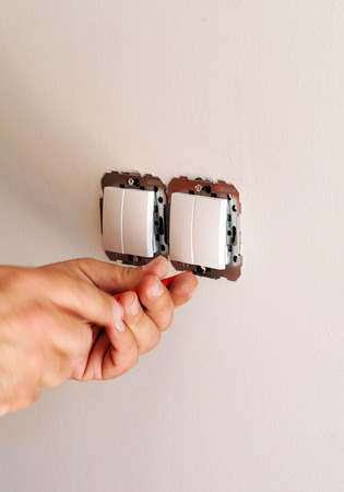 The electrician is installing new electrical switches in the houseの写真素材