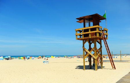 Watchtower with green flag on the beach of Bateles, Conil de la Frontera, Spainのeditorial素材