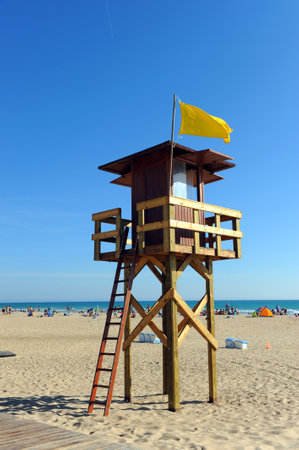 Watchtower with yellow flag on the beach of Bateles, Conil de la Frontera, Spainのeditorial素材