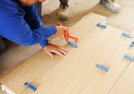 mason placing a new porcelain tile pavement in house