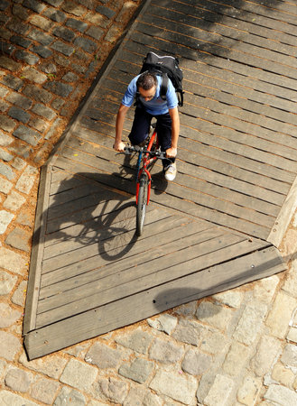 Cyclist moving around the city by bike on a wooden platform bike lane. Image taken from aboveのeditorial素材