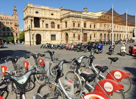 Bicycle rental service, sustainable and ecological transport. Sevici shared bike station in the Town Hall of Seville, Andalusia, Spain.のeditorial素材