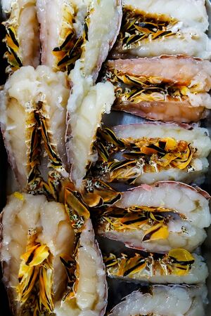 lobster tails cut in the middle on a metal trayの写真素材