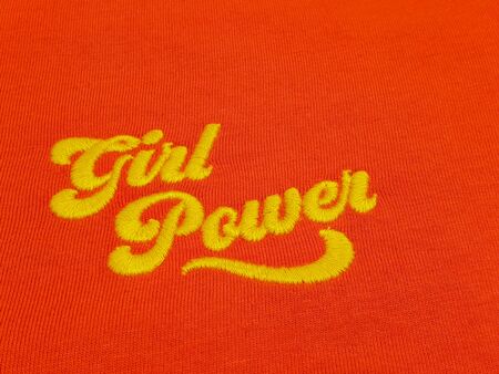 Yellow text girl power quote on vintage red cotton fabricの写真素材