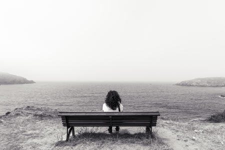 Girl sitting in the coast.の写真素材