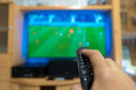 Watching a soccer game on television.の写真素材