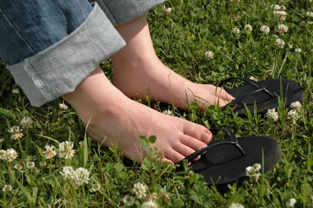 Woman Feet in Grass with White Flowersの写真素材
