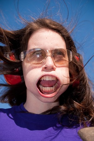 Young girl being blown away by high speed air.の写真素材