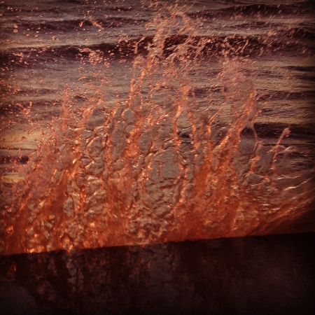 Water hitting a break wall at the beachの素材
