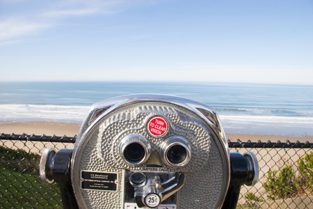 A view from behind a pay to use telescope at the beach along the Pacific Ocean.の写真素材