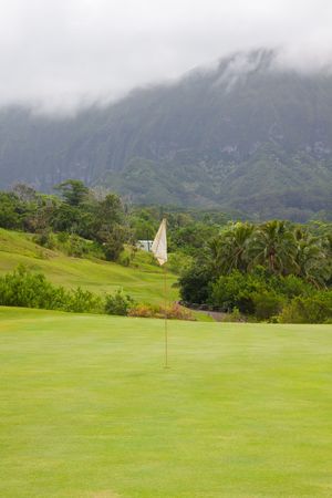 A great tropical golf course on oahu hawaii in the middle of a rainforest with magnificent greens and well manicured fairways.の写真素材