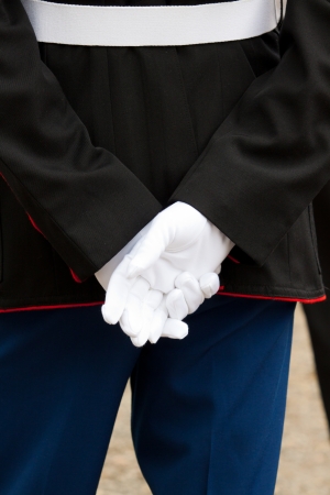 A marine soldier stands at attention during a wedding ceremony with his hands behind his back wearing full uniform and white gloves の写真素材