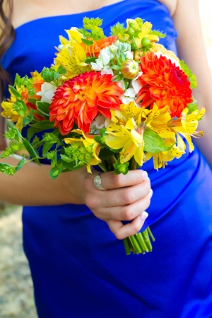 A bridesmaid holds her bouquet of beautiful flowers on a wedding day before the ceremony.の写真素材