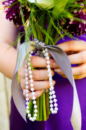 A bridesmaid holds her bouquet of beautiful flowers on a wedding day before the ceremony.の写真素材