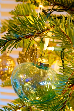 Elegant beautiful Christmas tree ornaments hang from this fir with lights and decorations all around.の写真素材