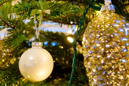 Elegant beautiful Christmas tree ornaments hang from this fir with lights and decorations all around.の写真素材