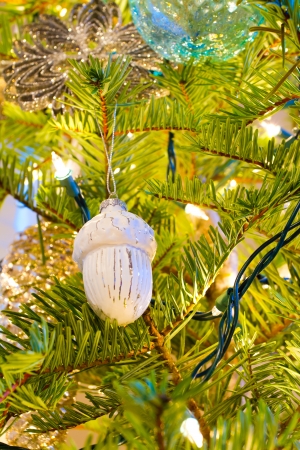 Elegant beautiful Christmas tree ornaments hang from this fir with lights and decorations all around.の写真素材