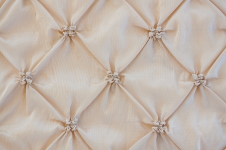 A tufted headboard with a beige tan tone to it at a wedding.の写真素材