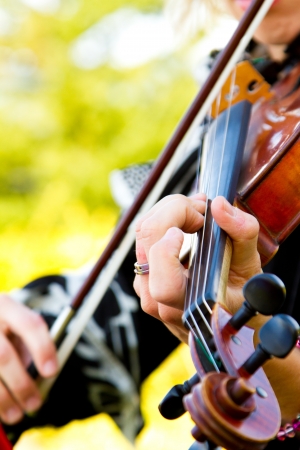 A close-up detail of a woman playing the violin at a wedding.の写真素材