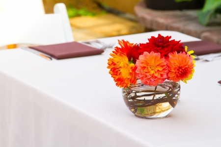Wedding decor at a ceremony and reception with beautiful red and yellow flowers.の写真素材