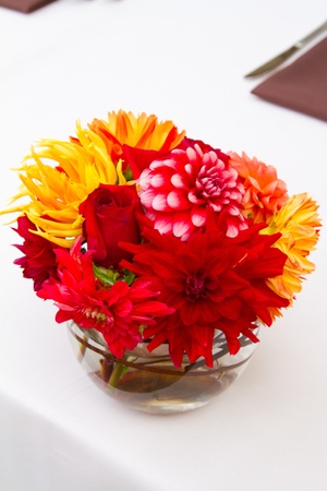 Wedding decor at a ceremony and reception with beautiful red and yellow flowers.の写真素材