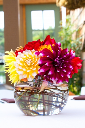 Wedding decor at a ceremony and reception with beautiful red and yellow flowers.の写真素材