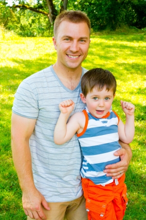A father has his arm around his son outdoors の写真素材
