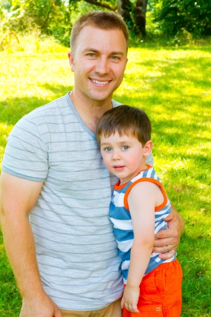 A father has his arm around his son outdoors の写真素材