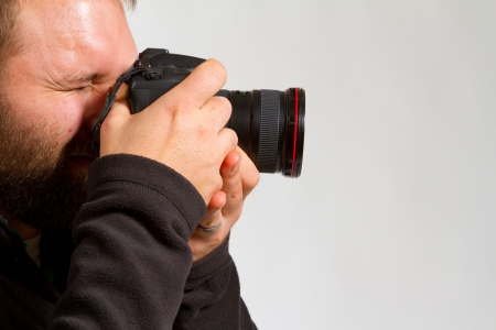 A photographer holds the camera like he is shooting photos の写真素材