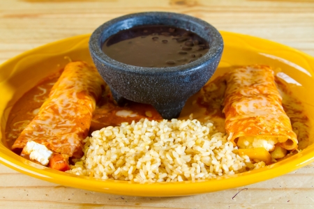 Enchiladas and rice and beans at a Mexican restaurant serving authentic cuisine.の写真素材