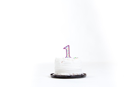 A white cake isolated against a white background in the studio for a baby first birthday.の写真素材