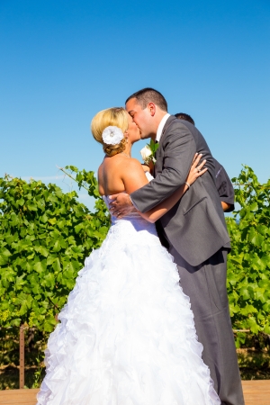 A bride and groom seal the deal with a kiss during their wedding day ceremony at a vineyard winery in Oregon.の写真素材