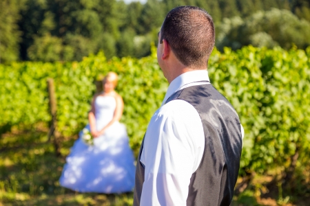 A shallow depth of field is used on this shallow focus layered shot of a bride and groom on their wedding day at a vineyard winery in Portland Oregon.の写真素材