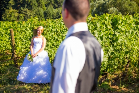 A shallow depth of field is used on this shallow focus layered shot of a bride and groom on their wedding day at a vineyard winery in Portland Oregon.の写真素材
