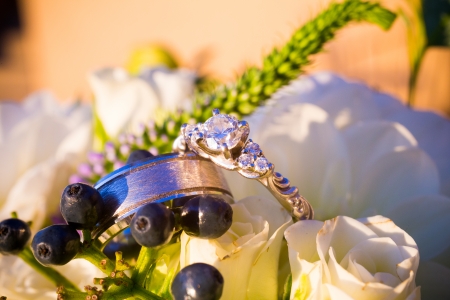 Wedding rings of the bride and groom are placed on flowers for a closeup color image.の写真素材