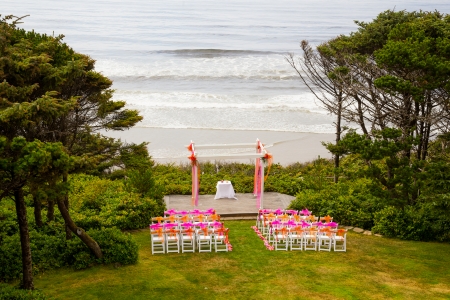 Chairs and decor are setup for this coastal wedding ceremony at the coast just above the beach along the pacific ocean.の写真素材