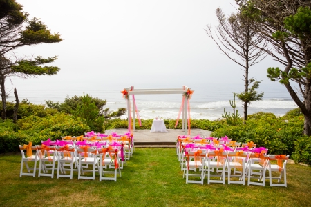Chairs and decor are setup for this coastal wedding ceremony at the coast just above the beach along the pacific ocean.の写真素材