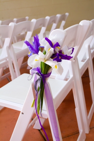 White wedding venue chairs are setup and ready in rows waiting for guests to arrive for the ceremony.の写真素材