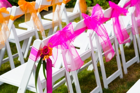 White wedding venue chairs are setup and ready in rows waiting for guests to arrive for the ceremony.の写真素材
