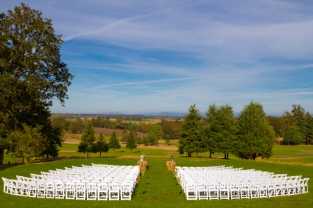 White chairs are setup waiting for the guests to arrive at this golf course outdoor wedding venue in Oregon during the summer.の写真素材