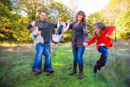 Nuclear family of five people including a mother father and three children stand together outdoors for this family picture.の写真素材