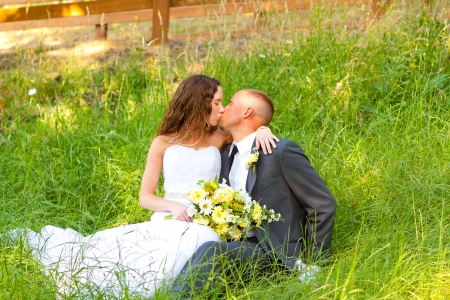 Bride and groom pose for a portrait on their wedding day outdoors at a country venue looking happy and in love together.の写真素材