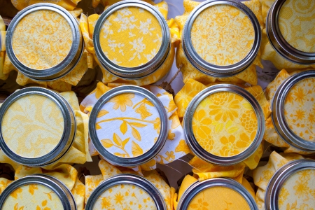A diy wedding project included these mason jars covered with yellow fabric for the reception guests.の写真素材