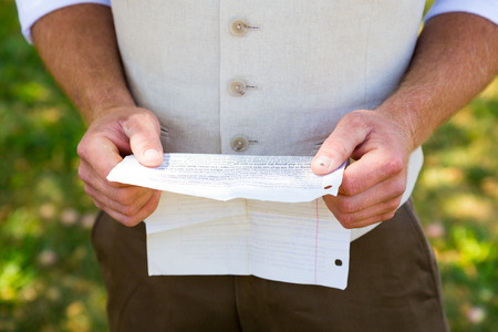 Handsome groom reading his vows for practice before the wedding ceremony.の写真素材