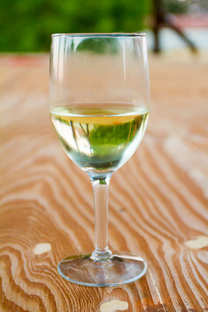 Pinot gris white wine in a glass on a wood surface at a wedding reception.の写真素材