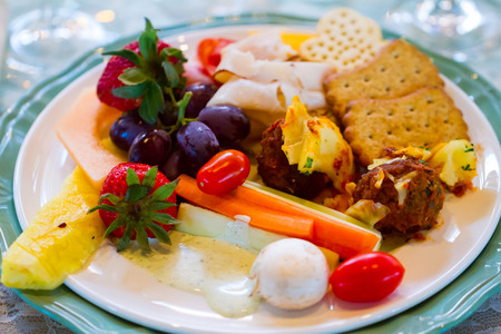 Wedding food at the reception includes dinner on a plate at a table.の写真素材