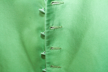 Green fabric of the vest of a groom on his wedding day.