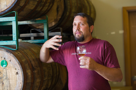 Eugene, OR, USA - July 17, 2014: Master brewer at Oakshire Brewing sampling and tasting bourbon...