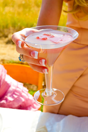Cocktail hour at a wedding reception with a person holding their drink.の写真素材